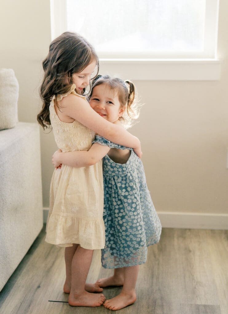Sisters hugging in a light filled living room